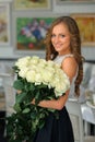 Portrait of a young beautiful caucasian woman with bouquet of white roses. Smiling Girl looking at camera Royalty Free Stock Photo