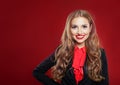 Portrait of young beautiful confident businesswoman in suit. Girl smiling and looking at camera on red background with copy space Royalty Free Stock Photo