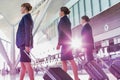 Portrait of young beautiful confident flight attendants walking in airport