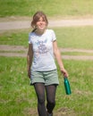 Portrait of young beautiful dark-haired woman wearing blue t-shirt drinking water at summer green park. Royalty Free Stock Photo