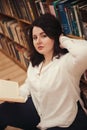 Portrait of young beautiful fashionable lady posing in library