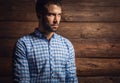 Portrait of young beautiful fashionable man against wooden wall. Royalty Free Stock Photo