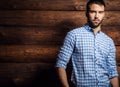 Portrait of young beautiful fashionable man against wooden wall. Royalty Free Stock Photo