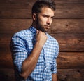 Portrait of young beautiful fashionable man against wooden wall. Royalty Free Stock Photo