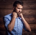 Portrait of young beautiful fashionable man against wooden wall. Royalty Free Stock Photo