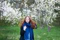 Portrait of a young beautiful fashionable woman in spring blossoming park. Happy girl posing in a blooming garden with white Royalty Free Stock Photo