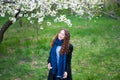 Portrait of a young beautiful fashionable woman in spring blossoming park. Happy girl posing in a blooming garden with white Royalty Free Stock Photo