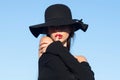 Portrait of a young beautiful fashionable woman wearing stylish accessories. Hidden eyes with hat. Romantic model woman Royalty Free Stock Photo