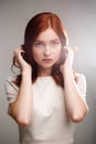 Portrait of young beautiful ginger girl over gray background with back light. Royalty Free Stock Photo