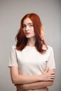 Portrait of young beautiful ginger girl over gray background with back light. Royalty Free Stock Photo