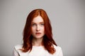 Portrait of young beautiful ginger girl over gray background. Royalty Free Stock Photo