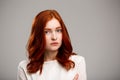 Portrait of young beautiful ginger girl over gray background. Royalty Free Stock Photo