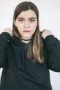 Portrait of young beautiful girl in black hoodie. Whie background. Natural soft daylight Royalty Free Stock Photo