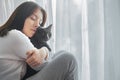 portrait of a young beautiful girl with a cat near the window