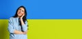 Portrait of young beautiful girl with dreamy and thoughtful facial epression isolated over blue and yellow ukrainian