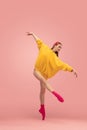 Portrait of young beautiful girl, female ballet dancer training isolated over pink background. Royalty Free Stock Photo