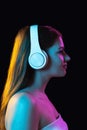 Portrait of young beautiful girl in headphones isolated over dark background. Royalty Free Stock Photo