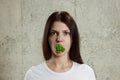 Portrait of a young, beautiful girl holding a broccoli in her mouth.. The concept of a healthy diet, detox, weight loss, diet, Royalty Free Stock Photo