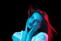 Portrait of young beautiful girl isolated on dark background in neon light Royalty Free Stock Photo