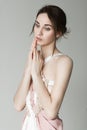 Portrait of a young beautiful girl in a light pink dress in the studio on a gray background Royalty Free Stock Photo