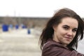 Portrait of a young beautiful girl with long brown hair. A cloudy autumn day on the beach Royalty Free Stock Photo