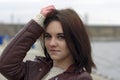 Portrait of a young beautiful girl with long brown hair. A cloudy autumn day on the beach Royalty Free Stock Photo