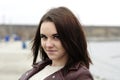 Portrait of a young beautiful girl with long brown hair. A cloudy autumn day on the beach Royalty Free Stock Photo