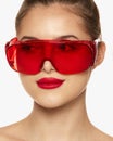 Portrait of young beautiful girl posing in red plastic glasses isolated over white background. Laser cosmetology Royalty Free Stock Photo