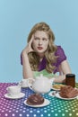 Portrait of young beautiful girl sitting at the table with pensive face. Retro blond. Rainbow style palette. Concept of