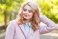 Portrait of a young beautiful girl in a pink coat. In the park. Royalty Free Stock Photo