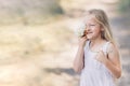 Portrait of a young beautiful girl who hides part of her face behind a hydrangea and smiles Royalty Free Stock Photo