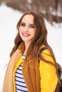 Beautiful girl in yellow coat posing on a background of a winter park Royalty Free Stock Photo