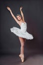 Portrait of young beautiful graceful caucasian ballerina practice ballet positions in tutu skirt of white swan from Swan Lake. Royalty Free Stock Photo