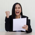 Portrait of young beautiful and happy Asian woman wearing smart casual laughing with friendly and cheerful face holding paper