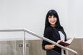 Portrait of Young Beautiful happy brunette woman dressed in a black business suit working with a notebook, standing in office, Royalty Free Stock Photo