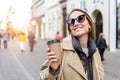 Portrait young beautiful happy smiling woman drinking coffee to go tea in eco sustainable paper cup wear biege trench Royalty Free Stock Photo