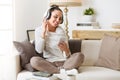 Woman listening music in headphones on a couch Royalty Free Stock Photo