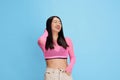 Portrait of young beautiful korean girl smiling, laughing, posing in colorful top against blue studio background Royalty Free Stock Photo