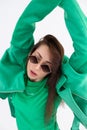 Portrait of young beautiful lady in green jacket and t-shirt with sunglasses. Attractive woman with trendy accessory and Royalty Free Stock Photo