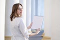 Portrait of a young nurse, medical university student standing with a phonendoscope and a blank sheet of paper, happy female