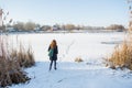 Portrait of a young beautiful red hair girl crossing frozen river Royalty Free Stock Photo