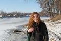Portrait of a young beautiful red hair european girl near the frozen river Royalty Free Stock Photo