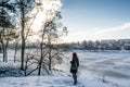 Portrait of a young beautiful red hair european girl standing near winter forest close to frozen river Royalty Free Stock Photo