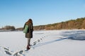 Portrait of a young beautiful red hair woman walking on the frozen river near forest Royalty Free Stock Photo