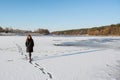 Portrait of a young beautiful red hair woman walking on the frozen snowy river near forest Royalty Free Stock Photo
