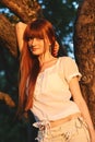 Portrait of a young beautiful red-haired woman in apple orchard Royalty Free Stock Photo