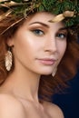 Portrait of young beautiful redhaired woman with firry wreath