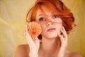 Portrait of young beautiful redhaired woman with yellow flower on a yellow background Royalty Free Stock Photo