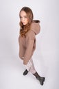 Portrait of young beautiful redhead woman in cozy clothes. Sexy female fashion model poses in taupe hoodie and skirt on Royalty Free Stock Photo