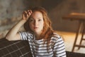 Portrait of young beautiful redhead woman relaxing at home in the autumn ot winter cozy evening Royalty Free Stock Photo